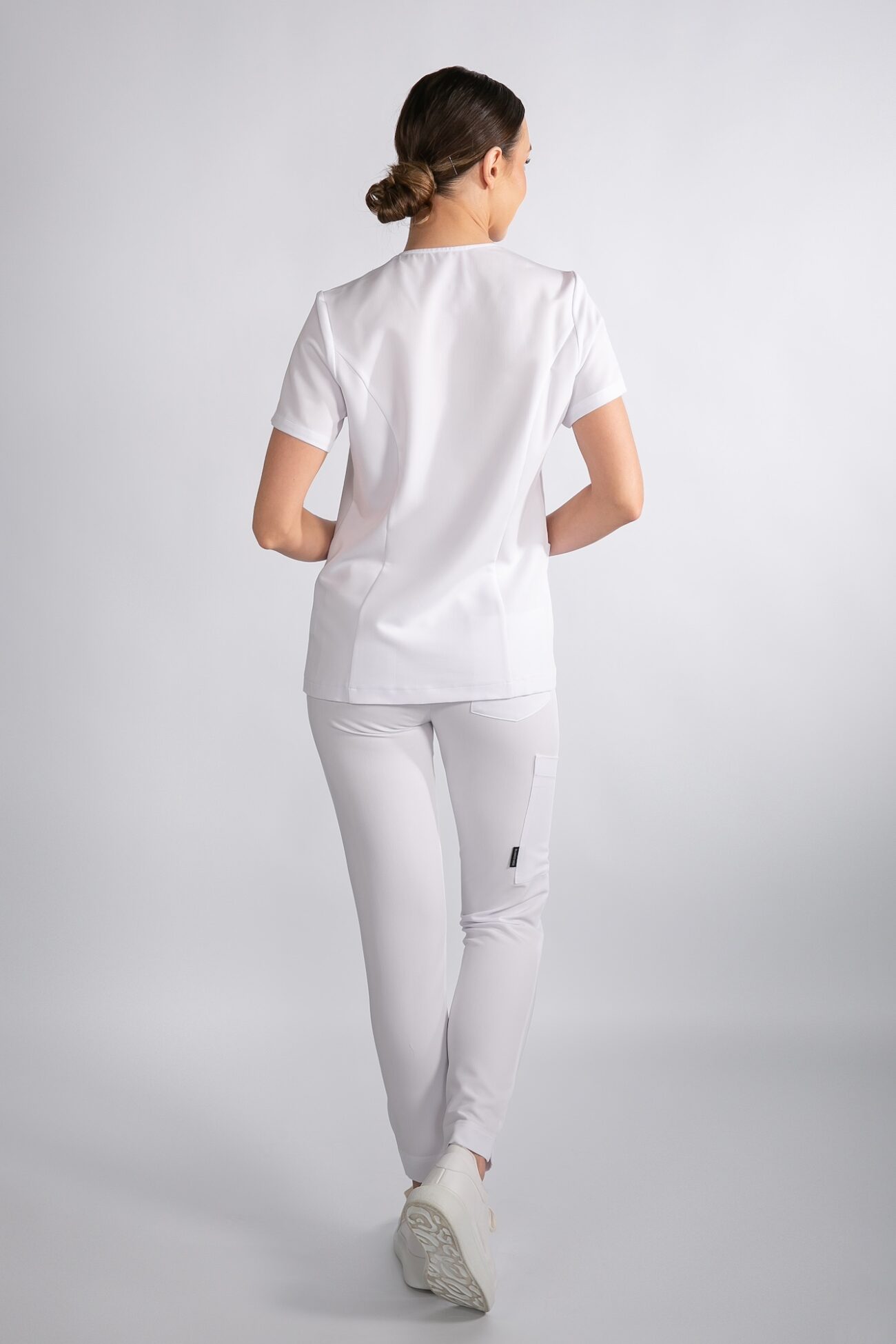 Tył spodni Comfy ProLine – Crystal White Modelka tyłem w spodniach medycznych Comfy ProLine – kolor Crystal White