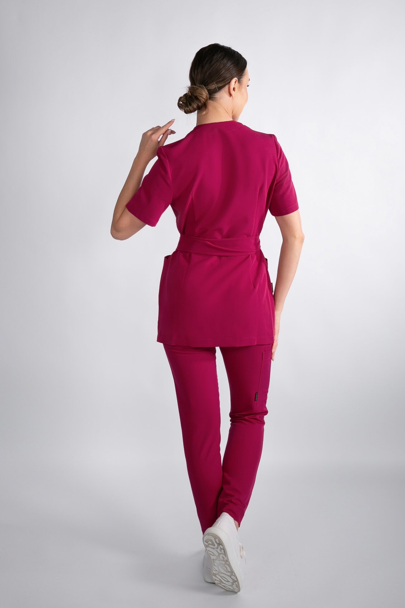 Tył tuniki medycznej damskiej Ruby Red Modelka tyłem w tunice medycznej Ruby Red – widok z tyłu
