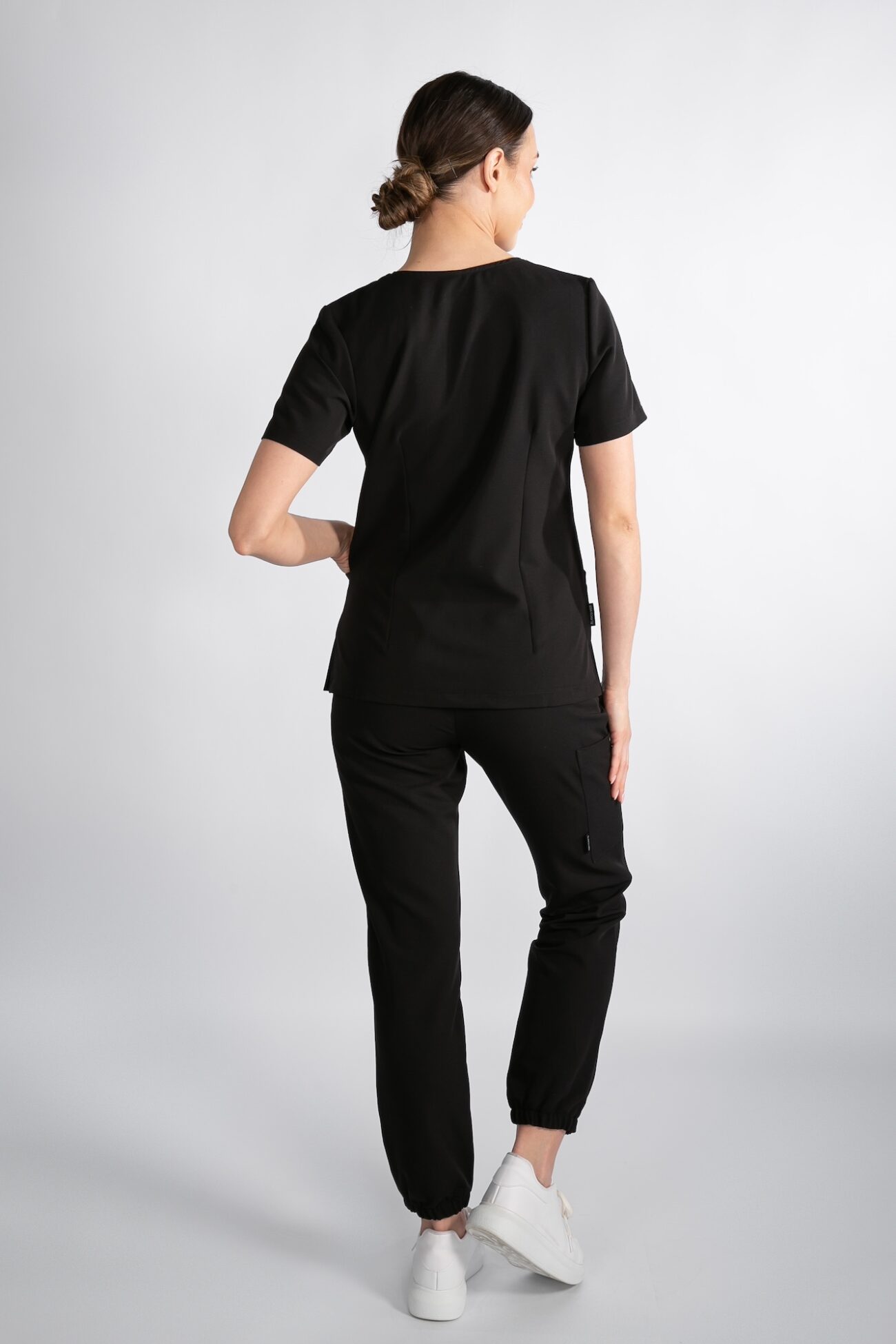 Tył bluzy Smart ProLine – Phantom Black Modelka tyłem w bluzie medycznej Smart ProLine – kolor Phantom Black
