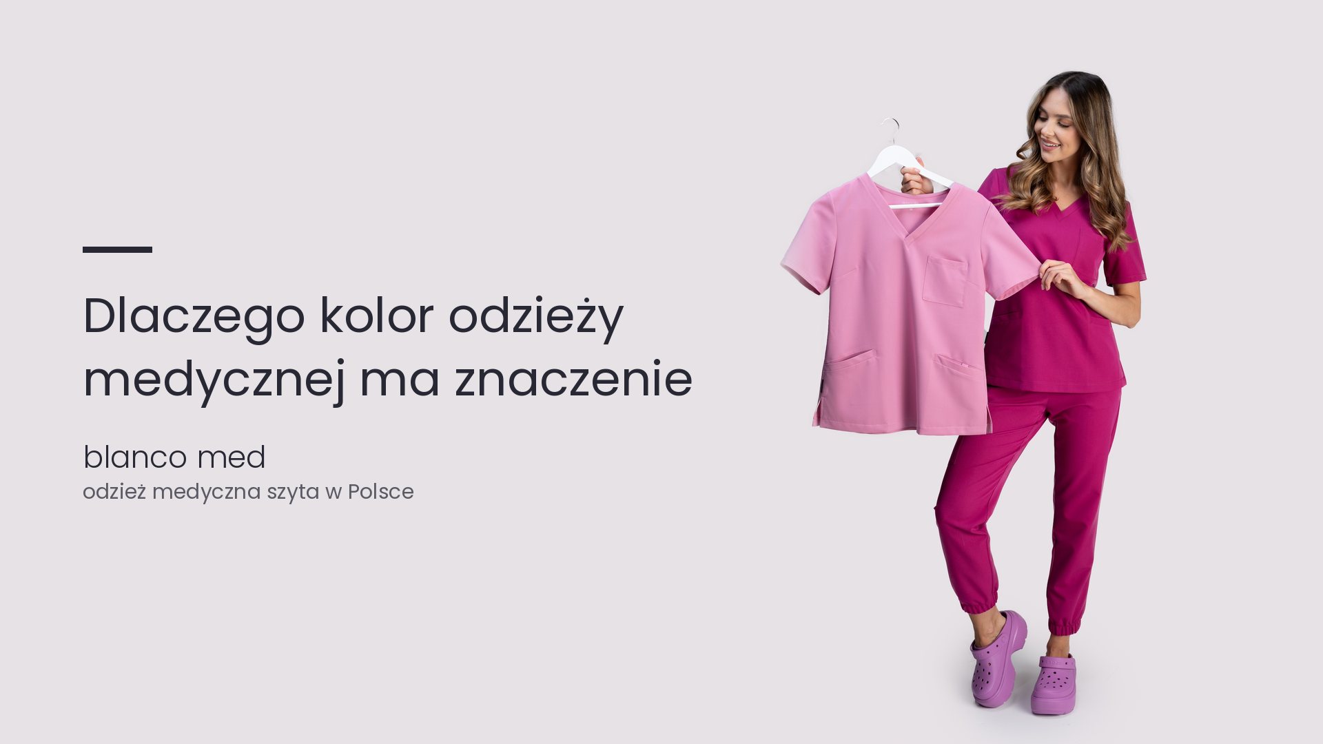 Kobieta w amarantowym komplecie medycznym trzyma różową bluzę medyczną. Dlaczego kolor odzieży medycznej ma znaczenie?